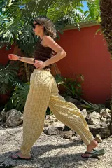 Pantalón de corte recto y holgado, con estampado de cuadros vichy en rojo y blanco. Tiene cintura elástica con cordón ajustable.