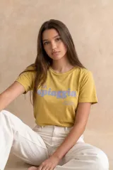 Remera de algodón peinado color pistacho, con cuello redondo, mangas cortas y estampado frontal con la leyenda "La Spiaggia By The Sea Summer Club" en tono celeste.