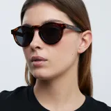 Gafas de sol redondas unisex, con montura carey y lentes polarizadas negras.