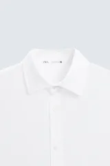 Camisa de corte regular fit confeccionada en tejido de lino, con cuello solapa, manga larga con puños abotonados y cierre frontal de botones.
