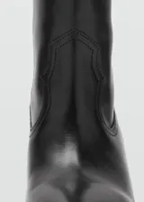 Bota de caña alta estilo cowboy confeccionada en piel bovina, con punta fina y tacón rectangular de 5 cm.