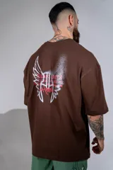 Remera oversize de algodón elastizado color marrón, con corte holgado y diseño de alas pequeñas estampado en el centro del pecho.