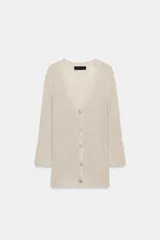 Chaqueta de punto color beige con escote en V, manga larga y cierre frontal con botones dorados.
