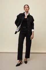 Jeans de corte straight y tiro medio, color negro, confeccionados en denim con spandex. Presenta un sutil tajo en la parte inferior del ruedo.
