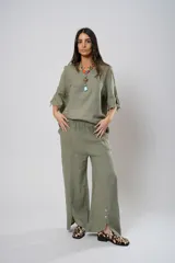 Pantalón de lino color verde seco, de corte amplio y relajado, con cintura elástica y detalle de aperturas laterales con botones de nácar en el ruedo.
