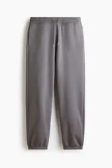 Pantalón deportivo de felpa con interior cepillado, corte relajado, cintura elástica con cordón de ajuste, bolsillos laterales y puños acanalados en los tobillos.