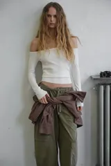 Top de punto ajustado al cuerpo con escote recto estilo off-shoulder y manga larga.