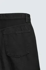 Pantalón jeans de corte recto y ajuste holgado, confeccionado en denim de algodón rígido. Presenta diseño clásico de cinco bolsillos, cierre frontal con cremallera y botón, con un acabado de lavado claro.