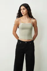 Top verde grisáceo con breteles finos y escote recto con detalle de encaje floral.