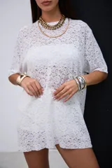 Remeron de encaje blanco con diseño floral, cuello redondo y mangas cortas de corte holgado.