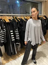 Buzo de lanilla con lurex color negro, de corte holgado y mangas largas. Presenta volados en los laterales inferiores.