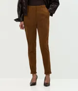 Pantalón skinny de mujer confeccionado en tejido sintético con efecto gamuza aterciopelado. Presenta un corte ajustado, recortes delanteros decorativos, cierre discreto y ruedo con dobladillo plegado.