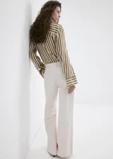 Jeans de algodón estilo wide leg en color beige, con diseño de tiro medio, cinco bolsillos, trabillas para cinturón y cierre frontal con botón y cremallera.