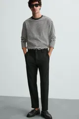 Pantalón chino de corte slim fit, confeccionado en tejido elástico. Presenta bolsillos frontales, bolsillos traseros de vivo con botón y cierre frontal con cremallera y botón.