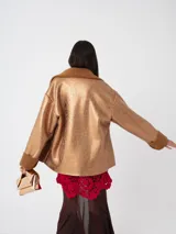 Campera oversized de cuero sintético negro con interior de piel sintética al tono, solapas amplias, cierre frontal y puños con detalle de piel.