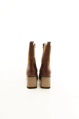 Bota de caña media combinada en cuero liso y descarne color marrón, con punta cuadrada, cierre lateral y taco ancho de madera.