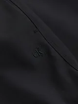 Pantalón negro de poliéster, de pierna ancha y talle alto. Tiene cierre con cremallera y broche, bolsillos laterales y monograma de Calvin Klein bordado.