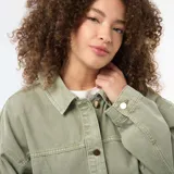 Sobrecamisa de twill color verde militar, de corte oversize, con cuello clásico, cierre frontal de botones metálicos y dos bolsillos delanteros de parche.