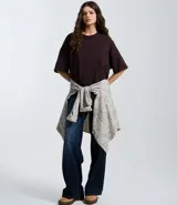 Remera oversize blanca de manga corta, con cuello redondo y diseño holgado, confeccionada en mezcla de algodón y poliéster.