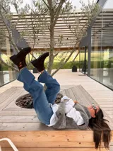 Botas cortas de cuero gamuzado color marrón oscuro, con suela track de goma negra y cierre frontal. Presentan un detalle de dos cruces bordadas a mano en tonos naranja y rojo en el lateral exterior.