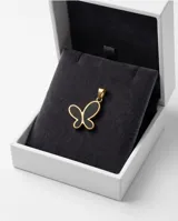 Dije de acero con baño de oro en forma de mariposa con relleno negro.