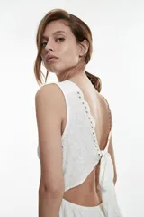 Vestido corto blanco con escote en V y detalle de puntilla en el escote.