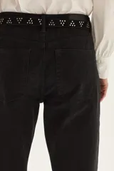 Cinturón de cuero gamuzado color camel, con diseño de tachas metálicas plateadas dispuestas en grupos triangulares y hebilla metálica labrada de estilo western.