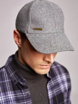 Gorra gris de fieltro con pequeños detalles de color y logo de la marca en el lateral.
