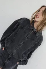 Campera de denim color negro con efecto lavado, corte semi oversize, cierre frontal completo, cuello camisero y bolsillos laterales.