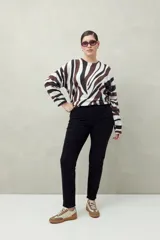 Pantalón chupín negro de tiro alto, confeccionado en denim suave y levemente elástico, con bolsillos delanteros y traseros.