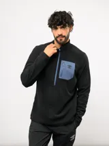 Buzo de entrenamiento Umbro con medio cierre frontal, cuello alto y bolsillo en el pecho de nylon con cierre. Presenta una textura sutil en el tejido y logo de la marca estampado en el bolsillo.