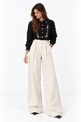 Pantalón de lino natural de tiro alto, corte wide leg y pinzas en la parte delantera. Cuenta con un pequeño bolsillo lateral con tapa y botón decorativo en la pretina.