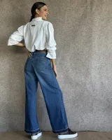 Pantalón de jean estilo wide leg con costuras verticales frontales, tiro alto y bolsillos laterales.