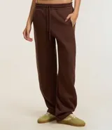 Pantalón de jogging marrón de algodón con forro de polar, corte amplio tipo barrel, cintura elástica con cordón de ajuste y bolsillos laterales.