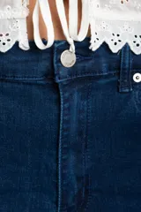 Jean de corte baggy con tiro medio, confeccionado en denim de algodón. Presenta un diseño de pierna ancha con estructura curva tipo barril y cierre frontal con botón y cremallera.