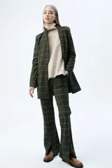 Pantalón acampanado a cuadros en tonos azul, marrón y negro, con cintura elástica y cordón ajustable.