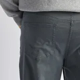 Pantalón de corte slim en color verde oscuro, con diseño de cinco bolsillos y cierre frontal con botón y cremallera.