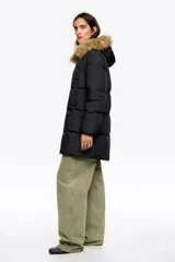 Campera tipo plumífero de largo medio y corte recto en tejido técnico, con cierre frontal, capucha con borde de pelo sintético desmontable y puños elásticos interiores. Presenta bolsillos laterales de vivo y etiqueta con logo en el pecho.