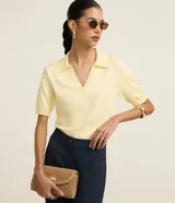 Blusa femenina de punto color amarillo pálido, con escote en V, cuello polo con detalle de mini perlas y mangas cortas.