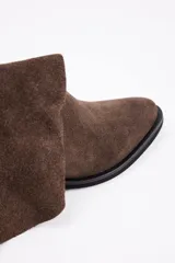 Bota de caña media estilo western, confeccionada en cuero vacuno con acabado de gamuza en color marrón, con taco cuadrado y puntera redondeada.