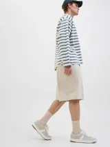 Short color beige de tiro medio con cierre de cremallera, bolsillos delanteros y traseros.