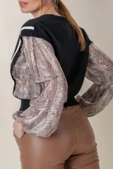 Buzo negro de lana fina con mangas largas abullonadas y laterales de seda con estampado animal print.