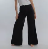 Pantalón de jean negro de corte wide leg, con tiro alto y cierre frontal con botón metálico.
