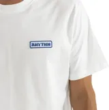 Remera de manga corta color blanco, con cuello redondo y logo de la marca Rhythm estampado en el pecho en un recuadro azul.
