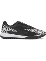 Championes de fútbol Under Armour Shadow Turf 3, diseñados para césped artificial. Presentan un diseño en color negro con detalles estampados en blanco y negro tipo pixelado. Cuentan con entresuela Charged Cushioning para absorción de impactos y suela de goma con tacos estratégicos para máximo agarre.