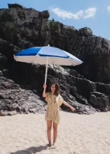 Vestido camisero corto blanco de algodón con bordados negros, cuello camisero, cierre frontal con botones y sin mangas.