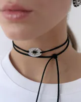 Choker de estilo bolo tie con cordón negro largo y dije central ovalado de acrílico espejado con diseño de estrella calada.