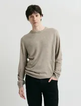 Sweater de tejido de punto con escote redondo y manga larga. Presenta un diseño clásico con detalles de terminación en sisas y cuello.