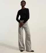 Blusa de manga larga confeccionada en punto negro, con cuello redondo y diseño ajustado.
