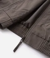 Campera rompeviento color verde militar, con cierre frontal de cremallera, cuello alto, puños y cintura elásticos. Presenta recortes delanteros y un pequeño logo estampado en el pecho.